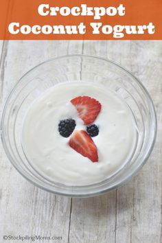 a glass bowl filled with yogurt and fruit on top of a wooden table