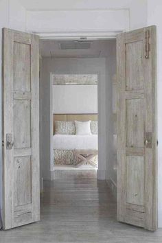 an open door leading to a bedroom with two beds in the room and another bed on the other side