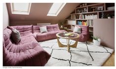 a living room with pink couches and bookshelves on the shelves in it