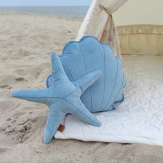 a blue starfish pillow sitting on top of a white blanket