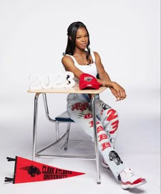 a woman sitting at a desk in front of a red and white sign that says 2013