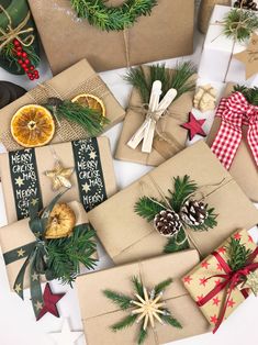 christmas presents wrapped in brown paper and decorated with pine cones, orange slices, firs, star ornaments and ribbons