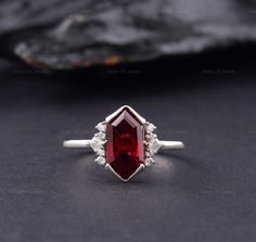 Dutch Marquise Red Ruby Lab Diamond Engagement Ring, Hexagon Cut Red Diamond Ring For Her, Dutch Marquise Cut Red Ruby Gemstone Ring Center Stone: Shape: Hexagon cut (Dutch Marquise) Type: Lab Created Ruby CTS: 2.50 CT Approx. Size: 12*7 mm Approx.  Color: Red Clarity: VVS Side Stone: CTS: 0.10ct Approx. Shape: Round And Princess Moissanite Color: DEF Clarity: VVS Also Available In Purple: www.etsy.com/listing/1585232812 Can Be Made In 10/14/18k Rose/Yellow/White Gold, Silver, Or Platinum. Why buy Moissanite over Diamond? ● Moissanite is pocket-friendly, it is almost 1/10 of the diamond price. ● Moissanite is Conflict-free and eco-friendly, whereas a diamond can be a conflicted diamond and it's non eco-friendly. ● There is no higher resale value of a diamond, in moissanite, you don't have Silver Ruby Engagement Ring, Red Diamond Engagement Ring, Dutch Marquise, Red Diamond Ring, Red Engagement Ring, Ascher Cut, Red Ruby Ring, Ring Hexagon, Hexagon Ring