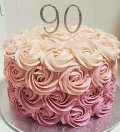 a cake with pink frosting roses and the number 90 on top