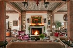 a living room filled with furniture and a fire place in the middle of a room