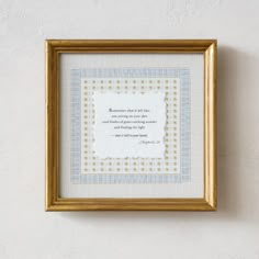 a frame with a poem on it hanging on the wall next to a white wall