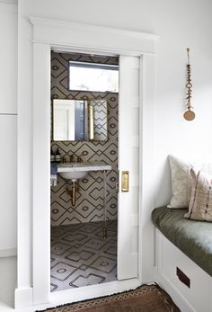 a bathroom with a sink and mirror on the wall, next to a window seat