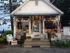 a small white building with lots of lights on it's front door and porch