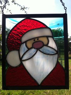 a stained glass santa clause hanging from a chain