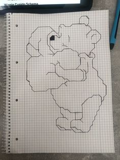 a piece of graph paper with a drawing of a map on it next to a pen