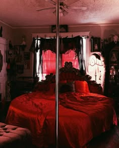 a bed with red sheets and pillows in a room