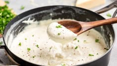 a wooden spoon in a pot filled with mashed potatoes