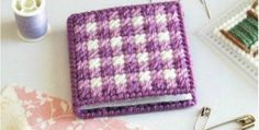 a purple and white crocheted book sitting on top of a table