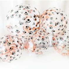 four clear balloons with orange and black polka dots on them, all filled with confetti