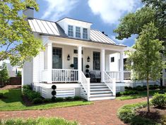 a small white house with porch and stairs