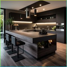 a modern kitchen with black cabinets and counter tops, lights above the sink, and bar stools