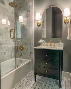 a bathroom with a sink, mirror and bathtub next to a walk in shower