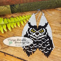 an owl beaded earrings is sitting on a table