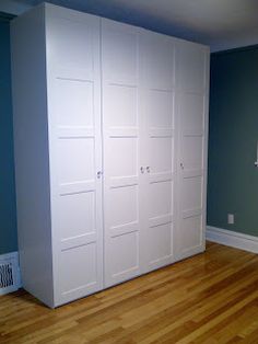 an empty room with blue walls and white closet doors on the left, hardwood flooring on the right