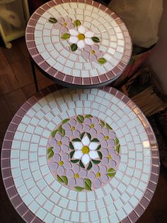 two plates sitting on top of each other with flowers painted on the inside of them