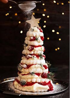 a christmas tree made out of meringue and strawberries is being sprinkled with sugar