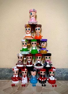 a group of dolls are stacked on top of each other in the shape of a christmas tree