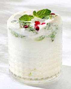 a white cake with green leaves and cranberries on top