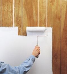 a man is painting the wall with white paint