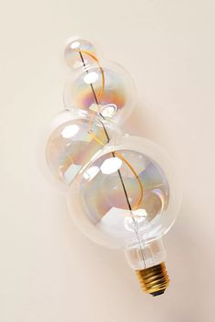 two light bulbs sitting next to each other on top of a white wall with bubbles