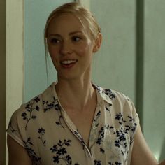 a woman with blonde hair wearing a floral shirt