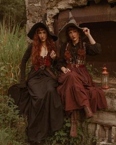 two women dressed in costumes sitting on steps