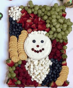 a platter with grapes, strawberries, crackers, and cheese in the shape of a clown