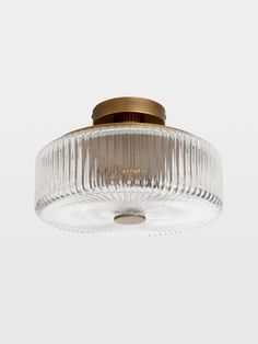 a glass ceiling light with a brass finish