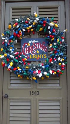 a christmas wreath on the front door of a building that has lights all over it