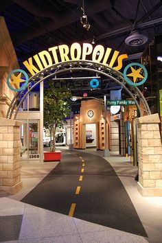 the entrance to an indoor mall that is decorated with signs and lights on it's sides