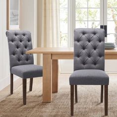 a dining room table with two chairs next to it and a window in the background