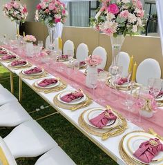 the table is set with pink napkins and gold plates