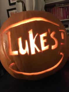 a carved pumpkin with the words luke's carved into it, sitting on a table