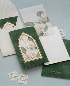 the wedding stationery is green and white with gold trimmings, featuring a church window