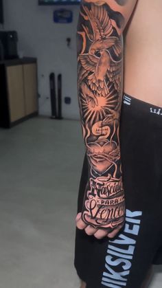 a man's arm with an eagle tattoo on it and some words in the background