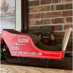 a wooden sleigh sitting on top of a mantle with a teddy bear next to it