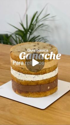 a cake sitting on top of a wooden table next to a potted green plant