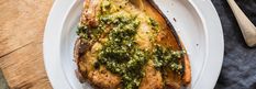 a white plate topped with meat covered in pesto