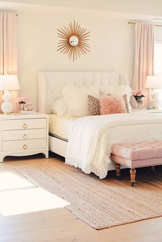 a white bed sitting in a bedroom on top of a wooden floor