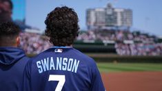 two baseball players standing on the field at a game in front of a large crowd