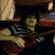 a person laying down with a guitar in their lap