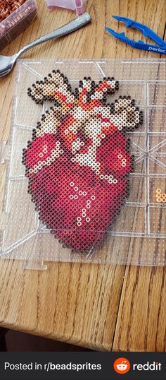 there is a cross - stitch heart on the table