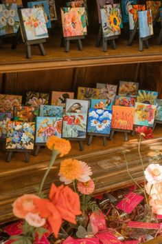 colorful cards and flowers on display in front of a wooden shelf filled with other greeting cards