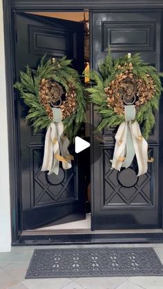 two wreaths on the front doors of a house