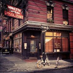 a bike parked on the sidewalk in front of a restaurant